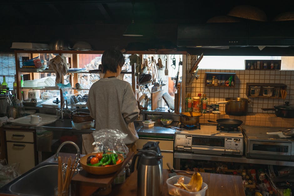 A person cooks in a traditional Japanese kitchen with various tools and ingredients.
